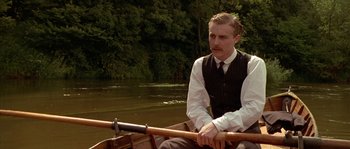 Movie still from “Howards End” (1992), directed by James Ivory – A man sitting in a row boat on a river; Medium shot, Low angle