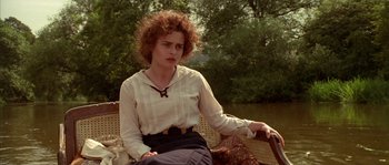 Movie still from “Howards End” (1992), directed by James Ivory – A woman sitting on a wicker chair in a park; Medium shot, High angle