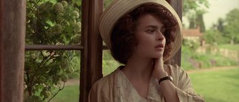 Movie still from “Howards End” (1992), directed by James Ivory – A young woman wearing a straw hat is leaning against a window; Close Up shot, Over the shoulder angle