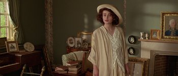 Movie still from “Howards End” (1992), directed by James Ivory – A woman in a hat standing next to a chair; Medium shot, Over the shoulder angle