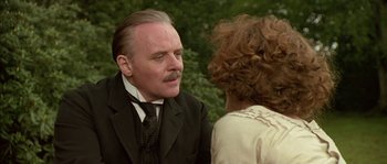 Movie still from “Howards End” (1992), directed by James Ivory – An older man in a suit talking to an older woman in a white dress; Close Up shot, Over the shoulder angle