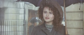 Movie still from “Howards End” (1992), directed by James Ivory – A young woman with curly hair and a rain hat; Close Up shot, Low angle