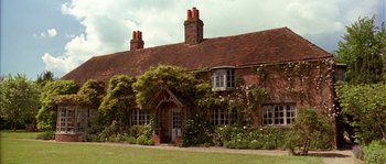 Movie still from “Howards End” (1992), directed by James Ivory – An old red brick house with a garden in front of it; Extreme Wide shot, Low angle
