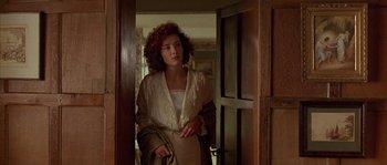 Movie still from “Howards End” (1992), directed by James Ivory – A woman standing in front of an open door; Medium shot, Over the shoulder angle