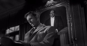 Movie still from “Hush...Hush, Sweet Charlotte” (1964), directed by Robert Aldrich – Black and white photograph of a man in front of a painting; Medium shot, Low angle