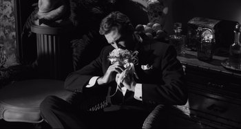 Movie still from “Hush...Hush, Sweet Charlotte” (1964), directed by Robert Aldrich – A black and white photo of a man in a suit holding flowers; Medium shot, High angle