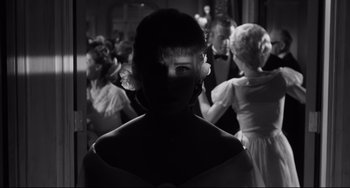Movie still from “Hush...Hush, Sweet Charlotte” (1964), directed by Robert Aldrich – A black - and - white photo of a woman's face in front of a group of people; Close Up shot, Low angle