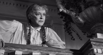 Movie still from “Hush...Hush, Sweet Charlotte” (1964), directed by Robert Aldrich – An older woman with braids standing in front of a tree; Close Up shot, Low angle