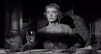 Movie still from “Hush...Hush, Sweet Charlotte” (1964), directed by Robert Aldrich – An older woman sitting at a table with a glass of wine; Close Up shot, Low angle