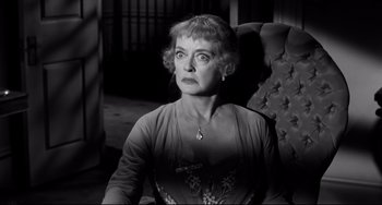 Movie still from “Hush...Hush, Sweet Charlotte” (1964), directed by Robert Aldrich – An older woman sitting in a chair in front of a window; Close Up shot, Over the shoulder angle