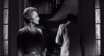 Movie still from “Hush...Hush, Sweet Charlotte” (1964), directed by Robert Aldrich – A woman standing next to a man wearing a suit; Medium shot, Low angle