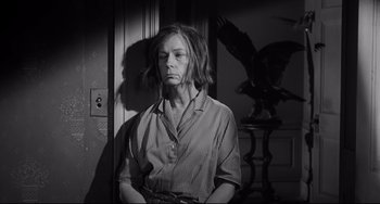 Movie still from “Hush...Hush, Sweet Charlotte” (1964), directed by Robert Aldrich – A woman is standing in a dark room; Medium shot, Low angle