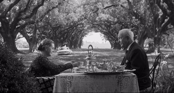 Movie still from “Hush...Hush, Sweet Charlotte” (1964), directed by Robert Aldrich – An older man and a woman sitting at a table; Wide shot, High angle
