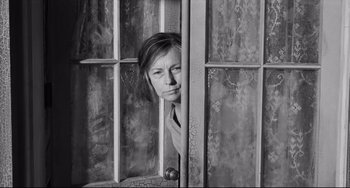 Movie still from “Hush...Hush, Sweet Charlotte” (1964), directed by Robert Aldrich – Black and white photograph of a woman peeking through a window; Close Up shot, High angle