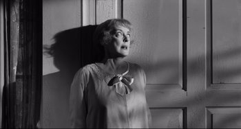 Movie still from “Hush...Hush, Sweet Charlotte” (1964), directed by Robert Aldrich – An older woman standing in front of a window; Medium shot, Low angle