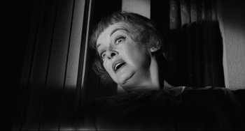 Movie still from “Hush...Hush, Sweet Charlotte” (1964), directed by Robert Aldrich – An older woman looking out of a window at night; Close Up shot, Low angle