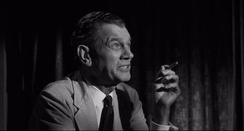 Movie still from “Hush...Hush, Sweet Charlotte” (1964), directed by Robert Aldrich – An older man in a suit and tie holding a cell phone; Close Up shot, Low angle