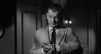 Movie still from “Hush...Hush, Sweet Charlotte” (1964), directed by Robert Aldrich – A black and white photo of a man in a suit and tie; Medium shot, Over the shoulder angle