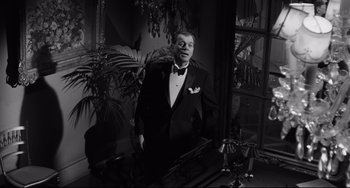 Movie still from “Hush...Hush, Sweet Charlotte” (1964), directed by Robert Aldrich – A black and white photo of a man in a tuxedo; Medium shot, Low angle