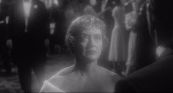 Movie still from “Hush...Hush, Sweet Charlotte” (1964), directed by Robert Aldrich – An older woman is looking at the camera in a black - and - white photo; Close Up shot, Over the shoulder angle