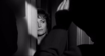 Movie still from “Hush...Hush, Sweet Charlotte” (1964), directed by Robert Aldrich – A black - and - white photo of a woman looking out a window; Close Up shot, Over the shoulder angle