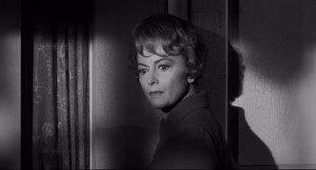 Movie still from “Hush...Hush, Sweet Charlotte” (1964), directed by Robert Aldrich – A black - and - white photo of a woman in front of a door; Close Up shot, Low angle