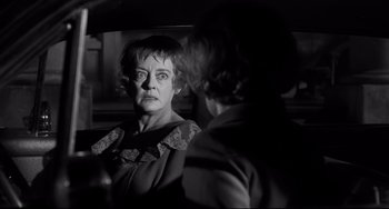 Movie still from “Hush...Hush, Sweet Charlotte” (1964), directed by Robert Aldrich – An older woman looking in the mirror while standing next to another woman; Close Up shot, Over the shoulder angle