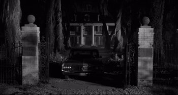 Movie still from “Hush...Hush, Sweet Charlotte” (1964), directed by Robert Aldrich – A car parked in front of a house in a black and white photo; Wide shot, Low angle