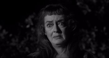 Movie still from “Hush...Hush, Sweet Charlotte” (1964), directed by Robert Aldrich – An older woman looking angry in a black - and - white photo; Close Up shot, Low angle
