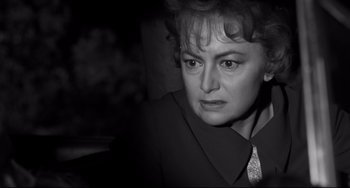 Movie still from “Hush...Hush, Sweet Charlotte” (1964), directed by Robert Aldrich – An older woman in a black suit looking at the camera; Close Up shot, Over the shoulder angle