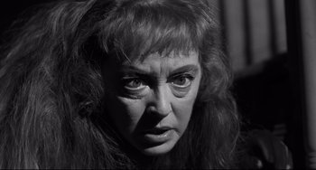 Movie still from “Hush...Hush, Sweet Charlotte” (1964), directed by Robert Aldrich – An old photo of an older woman looking at the camera; Close Up shot, Over the shoulder angle