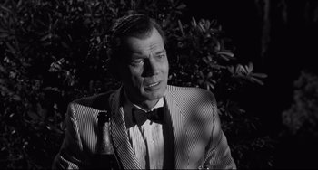 Movie still from “Hush...Hush, Sweet Charlotte” (1964), directed by Robert Aldrich – A man wearing a suit and bow tie in front of a tree; Close Up shot, Low angle