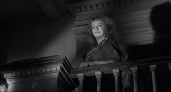 Movie still from “Hush...Hush, Sweet Charlotte” (1964), directed by Robert Aldrich – A black and white photo of a woman leaning on a railing; Medium shot, Low angle