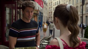 Movie still from “Emily in Paris” (2020), created by Darren Star – A man and a woman talking on the sidewalk; Medium shot, Over the shoulder angle