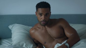 Movie still from “Emily in Paris” (2020), created by Darren Star – A man laying in a bed with a towel around his neck; Medium shot, High angle