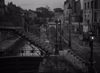 Movie still from “Hotel du Nord” (1938), directed by Marcel Carné – A black - and - white photo of a city street; Extreme Wide shot, High angle