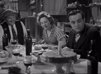 Movie still from “Hotel du Nord” (1938), directed by Marcel Carné – An old photo of people sitting at a dinner table; Medium shot, High angle