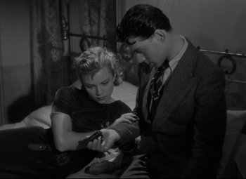 Movie still from “Hotel du Nord” (1938), directed by Marcel Carné – A man and a woman looking at each other while sitting at a table; Medium shot, High angle