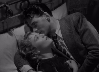 Movie still from “Hotel du Nord” (1938), directed by Marcel Carné – A man and a woman sitting next to each other on a bed; Medium shot, High angle