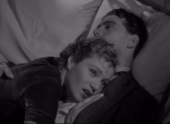 Movie still from “Hotel du Nord” (1938), directed by Marcel Carné – A man and a woman laying on a bed together; Medium shot, Overhead angle