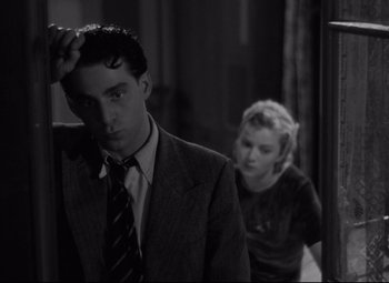 Movie still from “Hotel du Nord” (1938), directed by Marcel Carné – A man in a suit standing next to a woman; Medium shot, Low angle