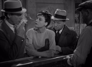 Movie still from “Hotel du Nord” (1938), directed by Marcel Carné – A man and a woman are smoking a cigarette in front of two other men; Medium shot, High angle