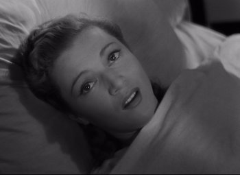 Movie still from “Hotel du Nord” (1938), directed by Marcel Carné – A black and white photo of a woman laying in bed; Close Up shot, Overhead angle