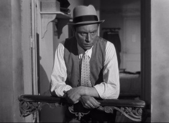 Movie still from “Hotel du Nord” (1938), directed by Marcel Carné – An old photo of a man wearing a hat; Medium shot, Low angle