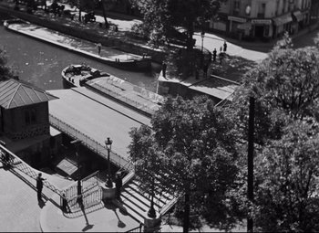 Movie still from “Hotel du Nord” (1938), directed by Marcel Carné – An aerial view of a city street with trees and benches; Extreme Wide shot, High angle