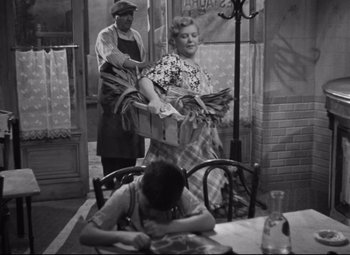 Movie still from “Hotel du Nord” (1938), directed by Marcel Carné – A man and a woman are holding a basket of food; Wide shot, High angle