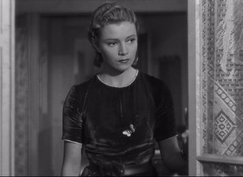 Movie still from “Hotel du Nord” (1938), directed by Marcel Carné – A woman in a black dress standing next to a wall; Medium shot, Over the shoulder angle