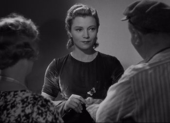 Movie still from “Hotel du Nord” (1938), directed by Marcel Carné – A black - and - white photo of a woman holding a pen; Close Up shot, Over the shoulder angle