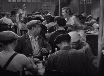 Movie still from “Hotel du Nord” (1938), directed by Marcel Carné – A group of people sitting at a table eating food; Medium shot, High angle
