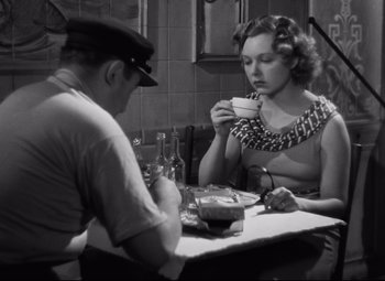 Movie still from “Hotel du Nord” (1938), directed by Marcel Carné – A man and a woman sitting at a dinner table; Medium shot, High angle